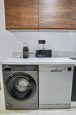 a kitchen with a washing machine and a counter at Luxueux Appartement Sécurisé in Casablanca