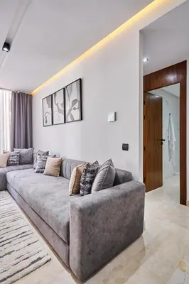 a living room with a gray couch in a room at Luxueux Appartement Sécurisé in Casablanca