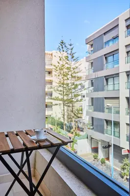 a table on a balcony with a view of a building at Luxueux Appartement Sécurisé in Casablanca