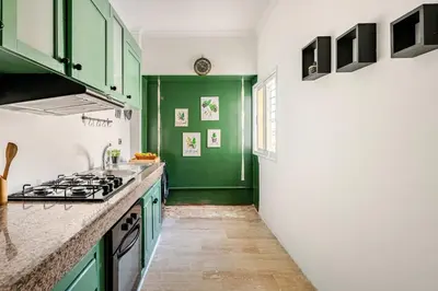 a kitchen with green cabinets and a stove at Modern, 1 BDR, AC, Parking, Elevator, Fiber Optic - Agdal in Rabat
