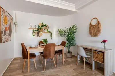 a dining room with a wooden table and chairs at Modern, 1 BDR, AC, Parking, Elevator, Fiber Optic - Agdal in Rabat