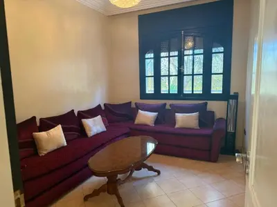 a living room with a purple couch and a table at VILLA BOUSKOURA Casablanca in Casablanca