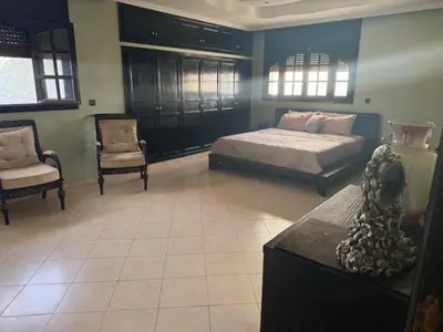 a bedroom with a bed and a couch and a chair at VILLA BOUSKOURA Casablanca in Casablanca