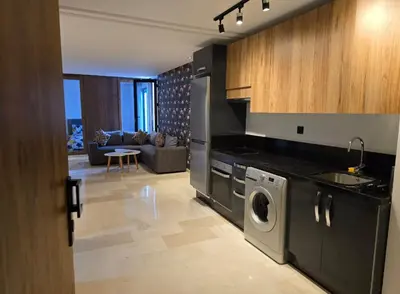 a kitchen with a washing machine and a living room at CASA Opal - Downtown Luxury Homes in Casablanca
