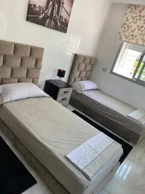 a bedroom with two beds and a window at Appartement pied sur mer in Mohammedia