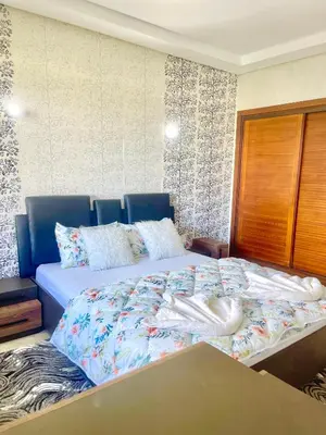 a bedroom with a large bed with a blue headboard at Taj collection 1 in Casablanca