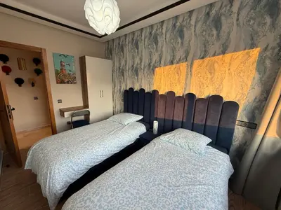 a bedroom with two beds and a painting on the wall at Sanctuaire Soleil & Luxe Casablanca in Casablanca