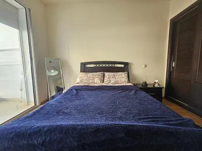 a bedroom with a bed with a blue blanket at Appartement au centre-ville, calme et lumineux in Casablanca