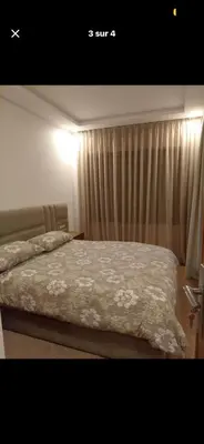 a bedroom with a bed and a window with curtains at Prestige appartements in Casablanca