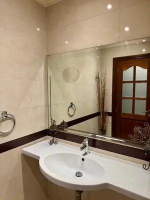 a bathroom with a sink and a large mirror at Spacious athène apartment in Maarif