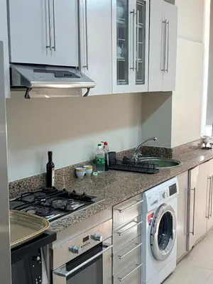 a kitchen with a stove and a washing machine at Très joli appartement très calme, très agréables pour un séjour en famille au haut Agdal Rabat in Rabat