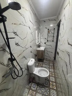 a bathroom with a toilet and a sink at Cozy Apartement next to the airport in Deroua
