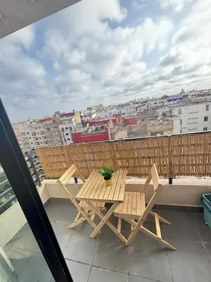 a wooden table and chairs on a balcony with a view at superbe loft au cœur de la ville in Casablanca