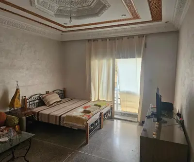 a bedroom with a bed and a large window at Hassan in Rabat
