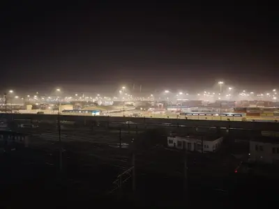 a city at night with a train yard with lights at Studio luxueux in Roches Noires