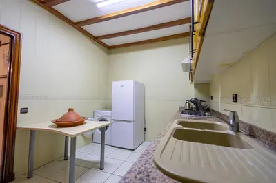 a kitchen with a sink and a white refrigerator at Bel appartement piscine & plage - Mohammedia in Mohammedia