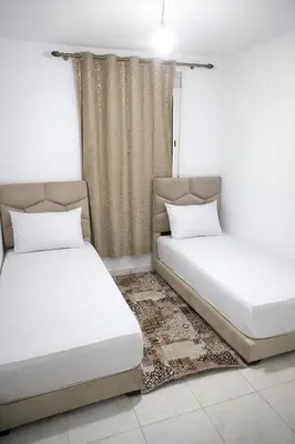 a bedroom with two beds and a window at appartement familial a 5min de l'hôpital Mohamed 6 in Bouskoura