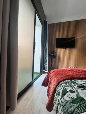 a bedroom with a bed and a large window at Elegant studio with large terrace in Rabat