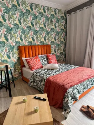 a bedroom with a bed and a table in it at Elegant studio with large terrace in Rabat
