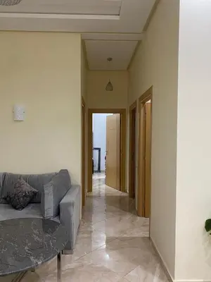 a living room with a couch and a table at 2 bedroom apartment in a secured residence, minutes to beach in Bouznika