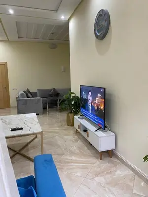 a living room with a flat screen tv on a wall at 2 bedroom apartment in a secured residence, minutes to beach in Bouznika
