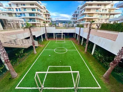 an indoor tennis court with palm trees on a building at Appartement 1 chambre à rabat imkan in Rabat