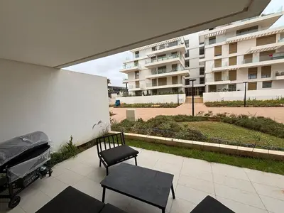 a patio with a chair and a bench and a building at Appartement 1 chambre à rabat imkan in Rabat