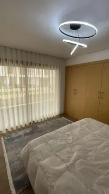 a bedroom with a large bed and a ceiling fan at Appartement 1 chambre à rabat imkan in Rabat