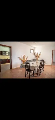 a dining room with a table and some chairs at Appartement spacieux à 15 minutes du stade Moulay Abdellah in Temara