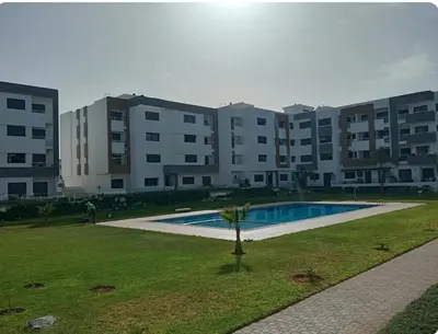 a large apartment building with a swimming pool in a park at A beautiful apartment for you in Rabat
