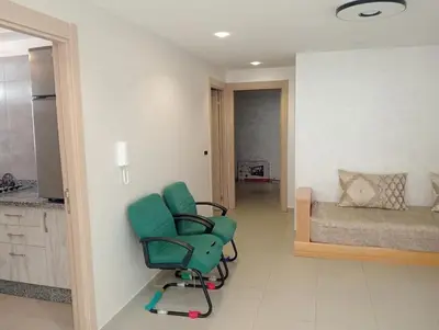 a green chair in a room with a bed at A beautiful apartment for you in Rabat