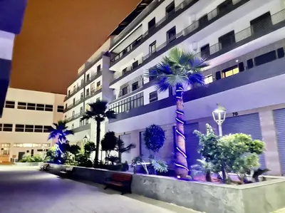 a large building with palm trees in front of it at La garonne in Casablanca