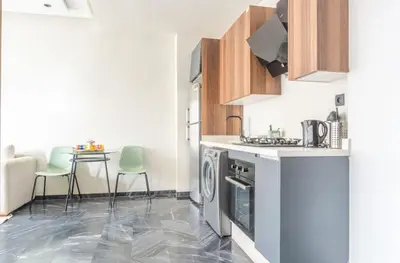 a kitchen with a stove top oven next to a table at Super Summit Apartments Le Phenix in Casablanca