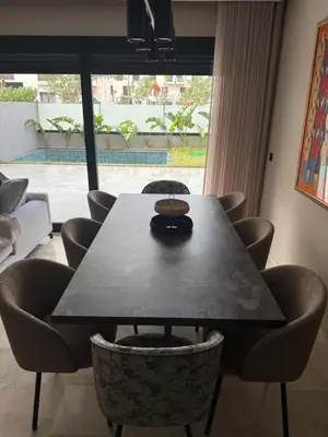 a table and chairs in a room with a large window at Appartement de luxe in Casablanca
