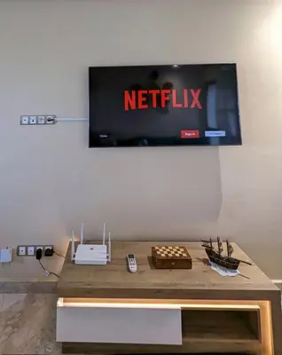 a television hanging on a wall above a table at Beachfront View Appartement in Mohammedia