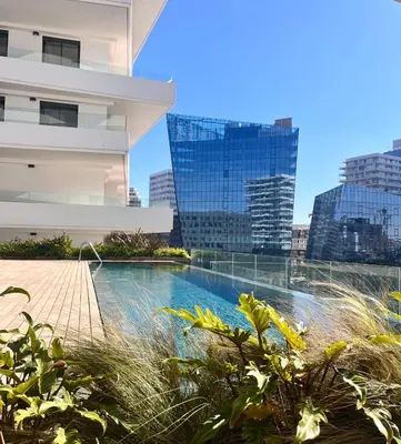 a swimming pool in front of a building with tall buildings at Charming 1-bedroom apartment, Casablanca Finance City in Casablanca