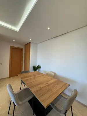 a conference room with a wooden table and chairs at Agdal Gare View Apartment in Rabat