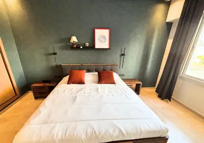 a bedroom with a large white bed with orange pillows at Grand Studio Moderne au Centre, Parking Privé in Casablanca