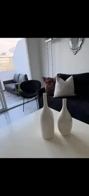 two white vases sitting on a table in a living room at Chez baya in Rabat