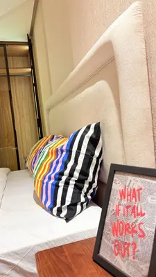 a bed with a pillow and a book on a table at stylish studio located in centre of casablanca in Casablanca