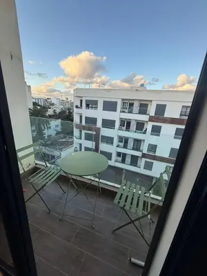 a table and chairs on a balcony with a building at Calme et Comfort ,cozy, centre de Casablanca in Casablanca