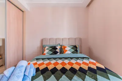 a bedroom with a bed with a colorful comforter at Confort Urbain - Plein centre & Spacieux in Casablanca