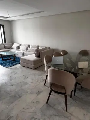 a living room with a couch and a table with a laptop at appartement de luxe a Mansouria in Mansouria