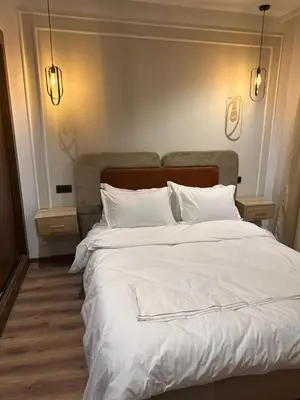 a large bed with white sheets and pillows at Studio Premium Maarif in Maarif