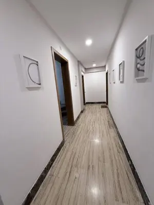 a hallway with white walls and a wooden floor at Appartement Haut Standing in Casablanca