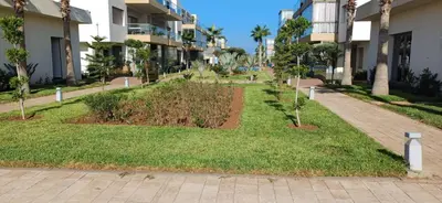 a garden in the middle of a building at Residence blue beach Sidi Rahal in Sidi Rahal