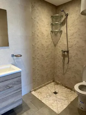 a bathroom with a shower with a toilet and a sink at Residence blue beach Sidi Rahal in Sidi Rahal