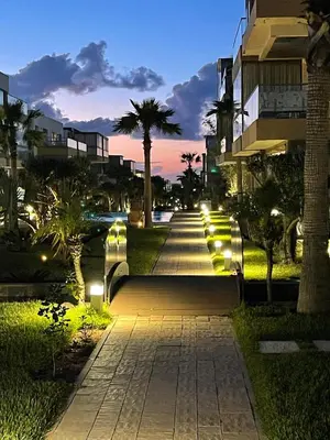 a walkway with lights in a city at night at Residence blue beach Sidi Rahal in Sidi Rahal