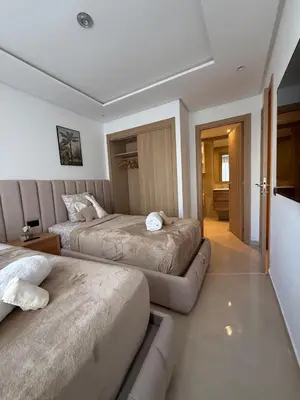 a bedroom with two beds and a couch at appartement de Lux le clos in Bouznika