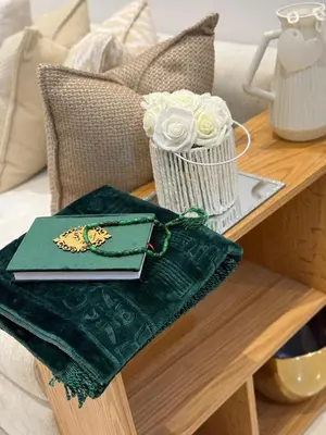 a table with a napkin and a vase of roses at appartement de Lux le clos in Bouznika
